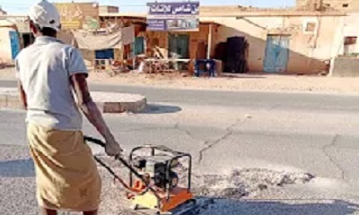 فريق الصيانة بمكتب الاشغال العامة والطرق بمديرية القطن يقوم بأعمال ردم الحفر في الاسفلت داخل المدينة و السوق التجاري